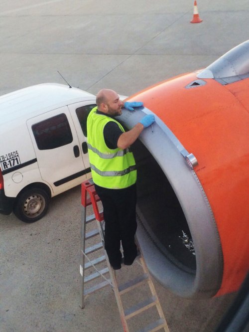 Работник аэропорта чинит турбину самолёта скотчем (2 фото)